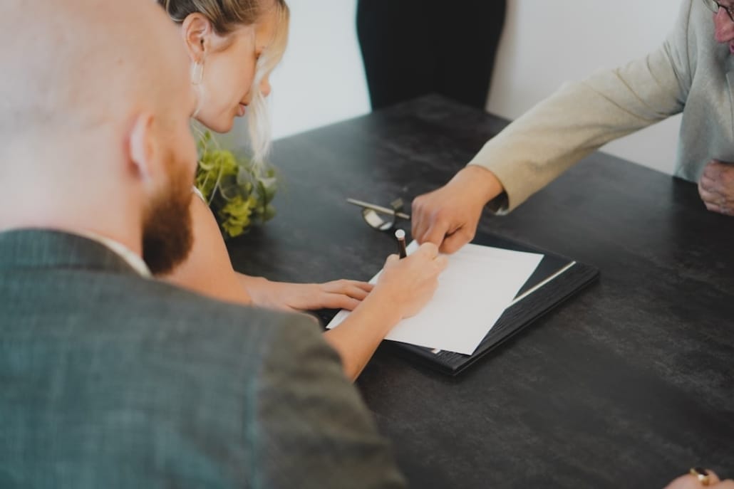Bureau d'affaires contemporain à Casablanca ou ville maghrébine moderne : lumière naturelle tamisée, documents financiers ouverts sur une table sobre, ambiance de travail analytique et confidentiel. Pas de personnes identifiables. Tonalité froide et maîtrisée.