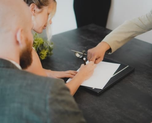 Bureau d'affaires contemporain à Casablanca ou ville maghrébine moderne : lumière naturelle tamisée, documents financiers ouverts sur une table sobre, ambiance de travail analytique et confidentiel. Pas de personnes identifiables. Tonalité froide et maîtrisée.
