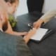 Bureau d'affaires contemporain à Casablanca ou ville maghrébine moderne : lumière naturelle tamisée, documents financiers ouverts sur une table sobre, ambiance de travail analytique et confidentiel. Pas de personnes identifiables. Tonalité froide et maîtrisée.