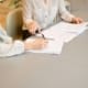 Deux personnes en réunion de travail concentrées sur des documents chiffrés ou un écran d'analyse financière, sans sourire forcé, ambiance sérieuse et confidentielle. Tenue professionnelle, bureau sobre et moderne.